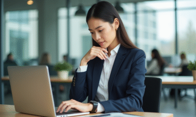 Jeune femme en costume navy vérifiant l'heure au bureau